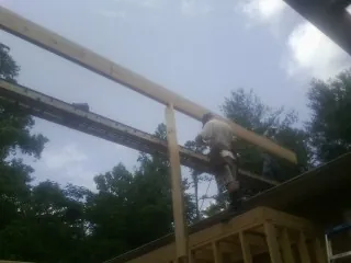 Carpenter setting a ridge beam over a new addition frame — Ice Dam Removal by Roofing Brothers in Withams