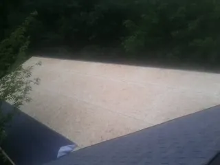 New OSB roof sheathing installed beside an existing shingle roof in Withams