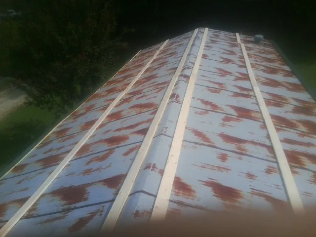 Rusted metal roof panels with new wood purlins before replacement — Storm Damage Roof Repair in Withams by Roofing Brothers