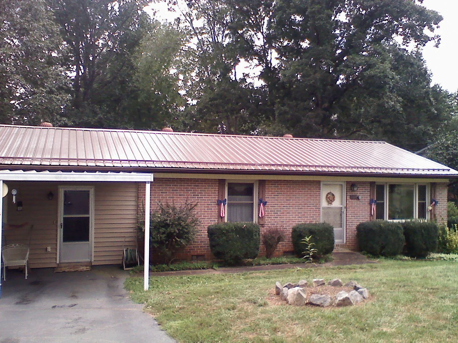 Bronze metal roof and carport on a brick ranch home — Roof Repair work by our crew in Withams